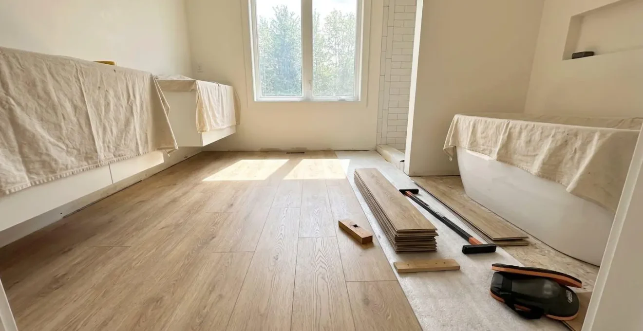 Pose de plancher vinyle WPC dans une salle de bain moderne, lames à motif bois clair installées en pose flottante